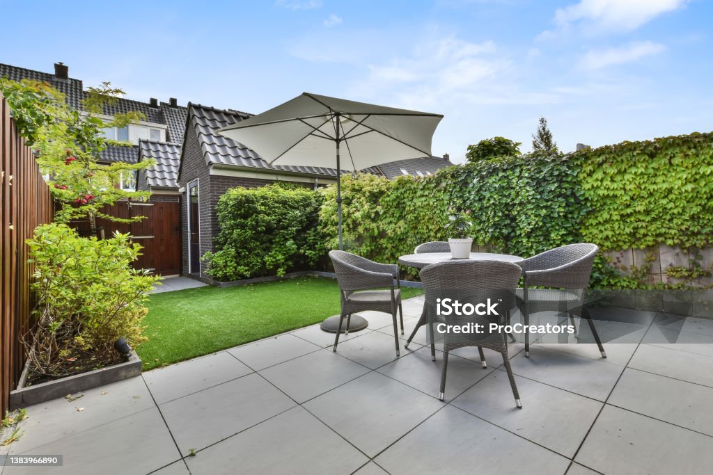 Hinterhof in einem gemütlichen Haus mit einer kleinen Sitzecke und einem Garten