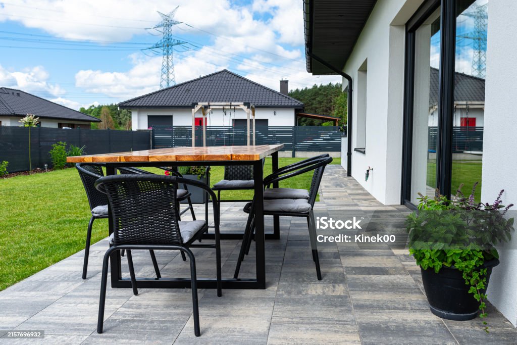 Ein moderner Tisch aus Rohholz mit Yachtlack überzogen, der auf der Gartenterrasse steht.